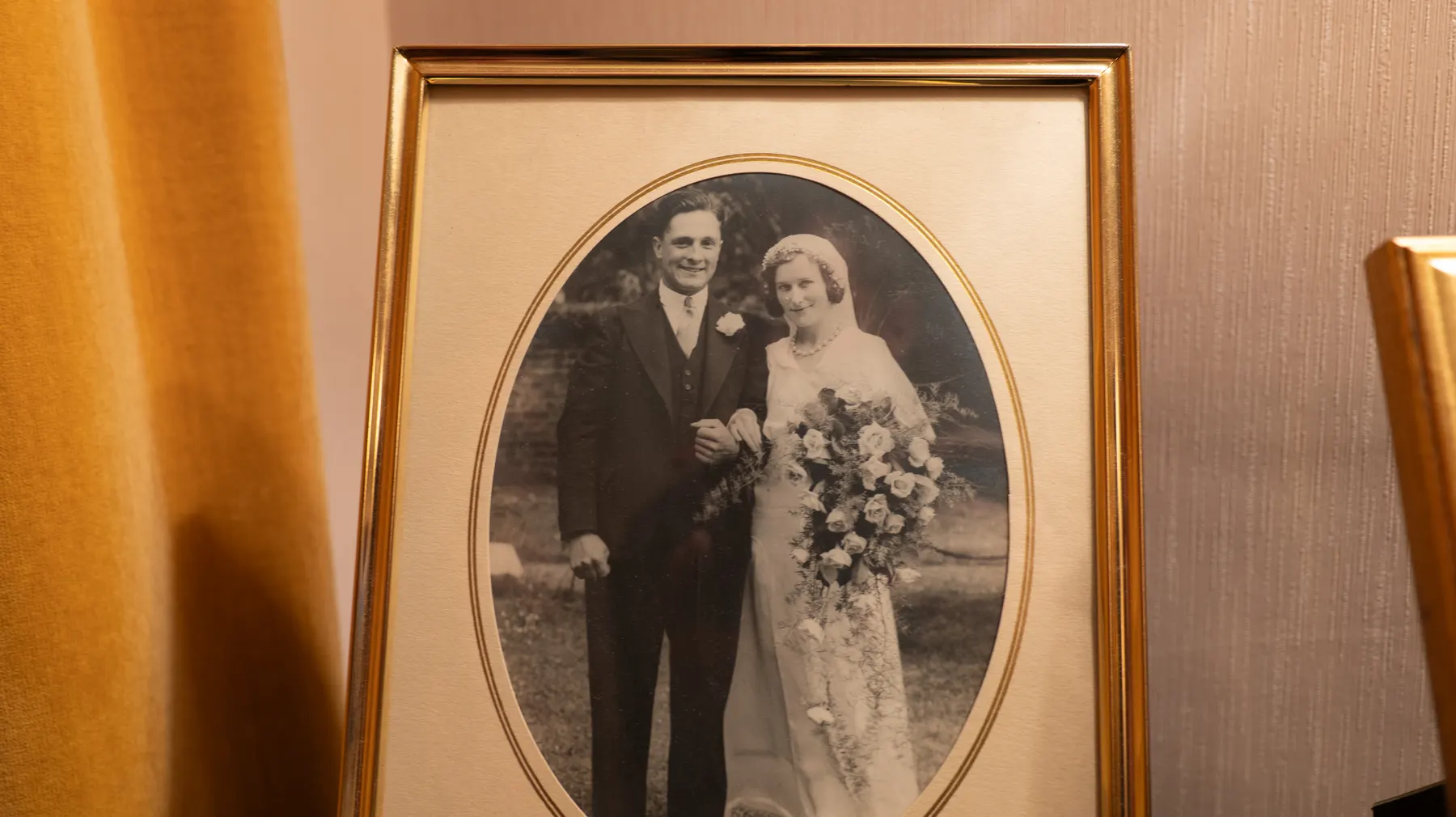 A framed wedding portrait from the 1940s on a living room wall
